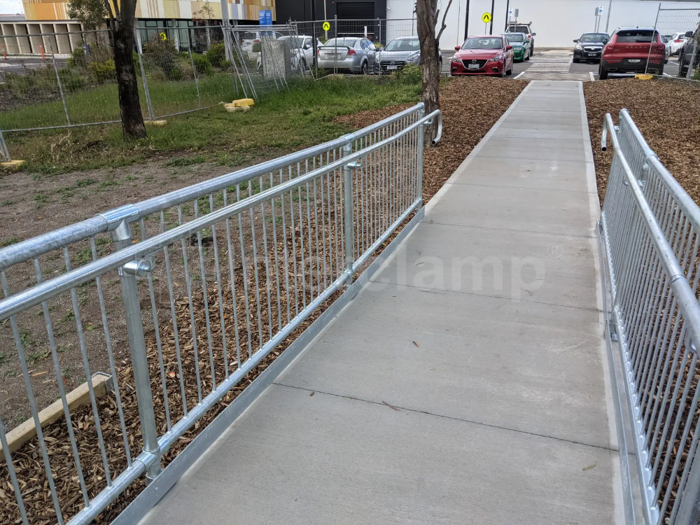 Interclamp pedestrian barriers and key clamp DDA assist rail used to construct safety barriers at a bus stop, ensuring safe and organized pedestrian flow.